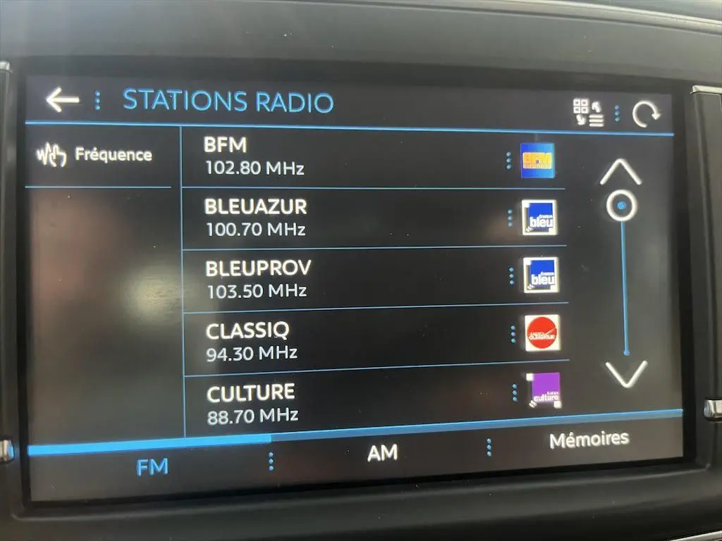 Écran tactile du système radio FM du Peugeot Expert Fourgon blanc, affichant plusieurs stations disponibles.