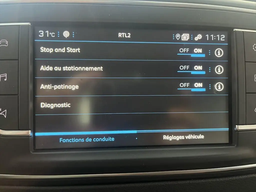 Écran tactile intérieur du Peugeot Expert Fourgon blanc 2019 montrant les réglages d'aide à la conduite activés.