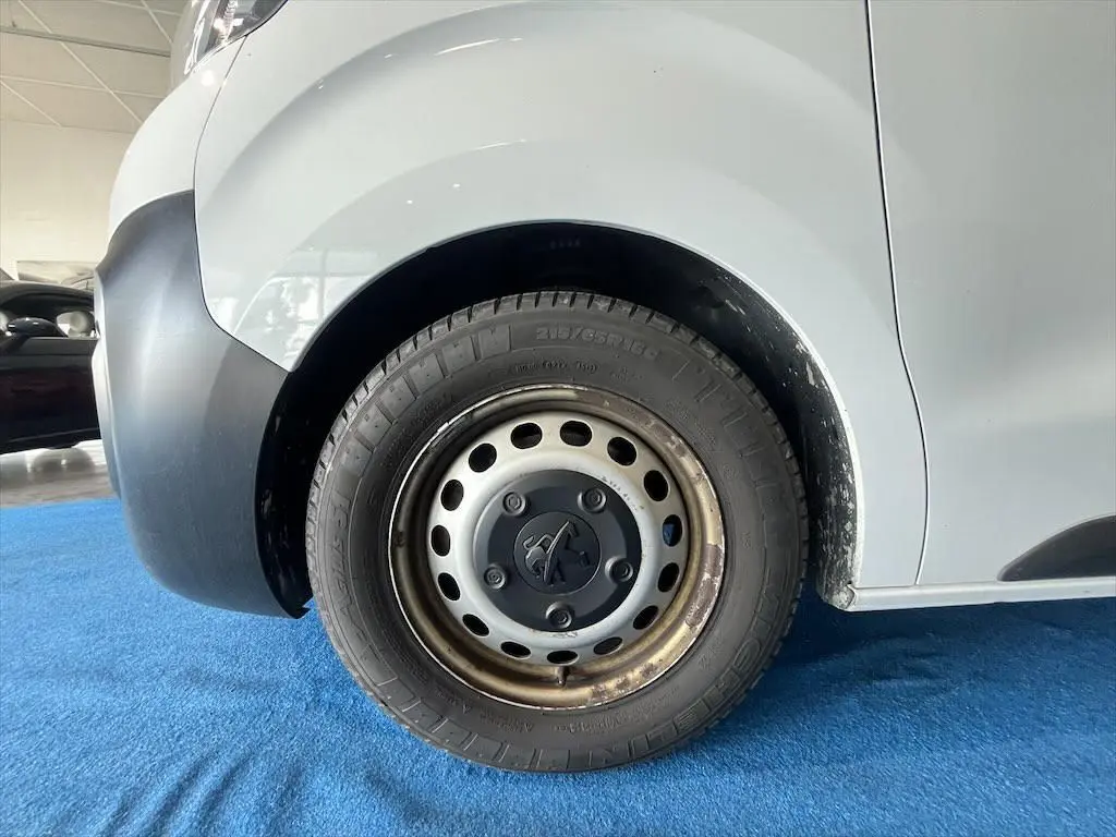 Gros plan sur la roue avant gauche du Peugeot Expert Fourgon blanc, avec jante acier et logo Peugeot central.