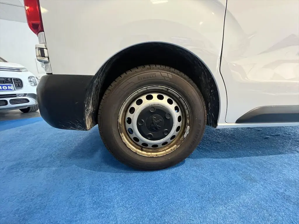 Gros plan sur la roue arrière gauche du Peugeot Expert Fourgon blanc, avec jante acier et logo Peugeot central.