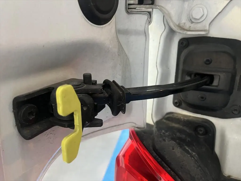 Gros plan sur la charnière de la trappe à carburant blanche du Peugeot Expert Fourgon, avec un détail jaune visible.