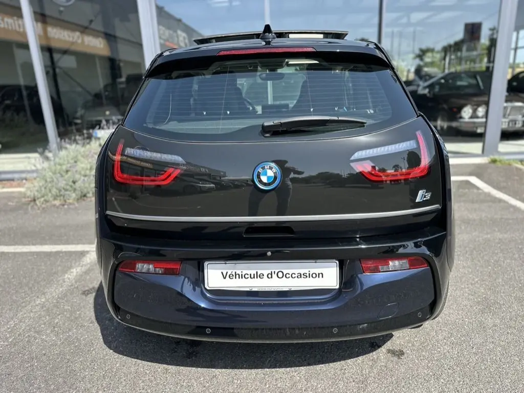 Vue arrière d'une BMW i3 électrique bleue de 2022 avec feux LED distinctifs et logo BMW visible.