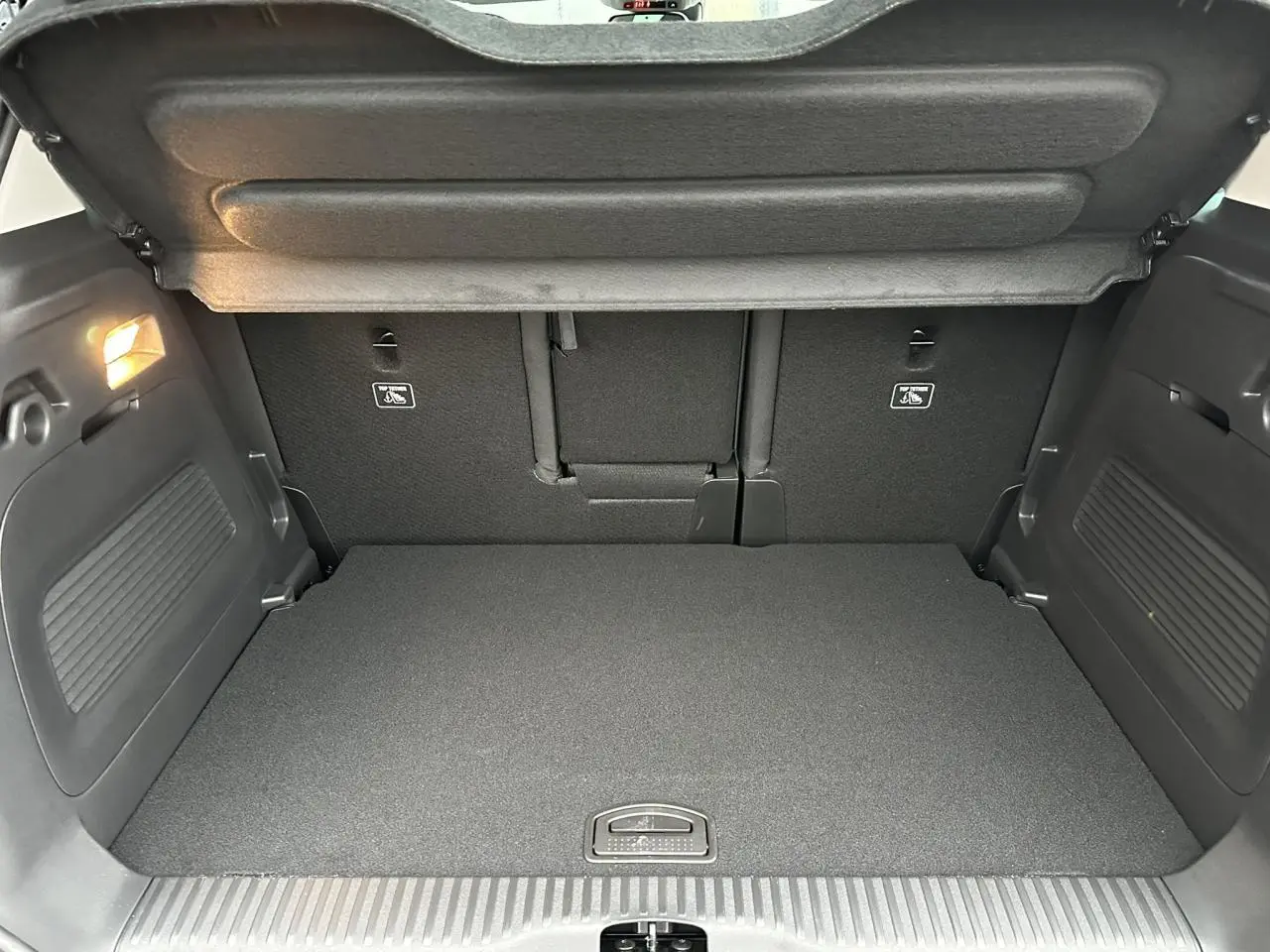Coffre ouvert vu de l'arrière du Citroën C3 Aircross Noir Perla avec banquette arrière et éclairage intérieur.