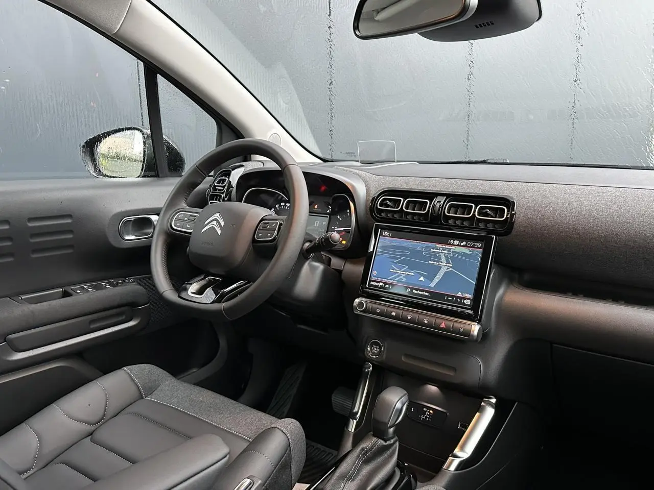 Intérieur avant gauche du Citroën C3 Aircross noir Perla, avec tableau de bord et GPS tactile allumé.
