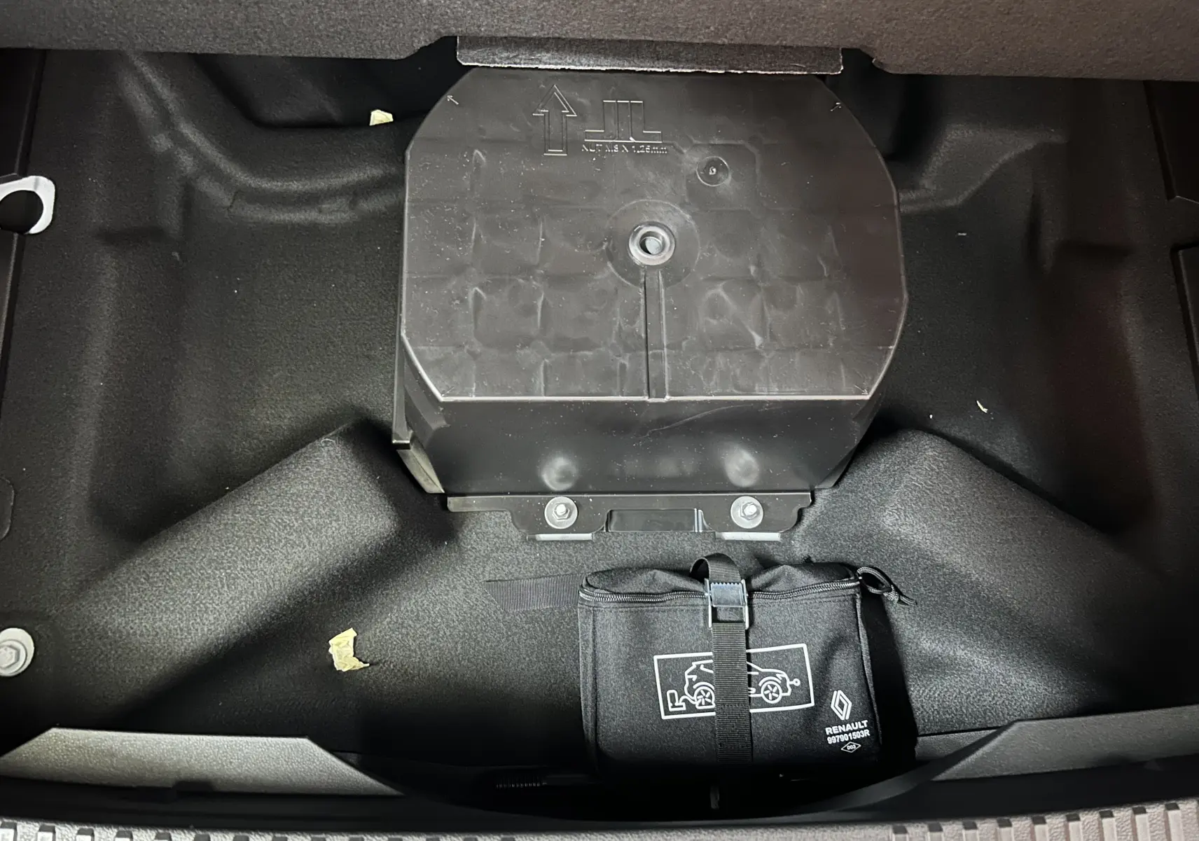 Vue plongeante sur le coffre avant du Renault Austral blanc nacré, montrant un rangement noir avec logo Renault.