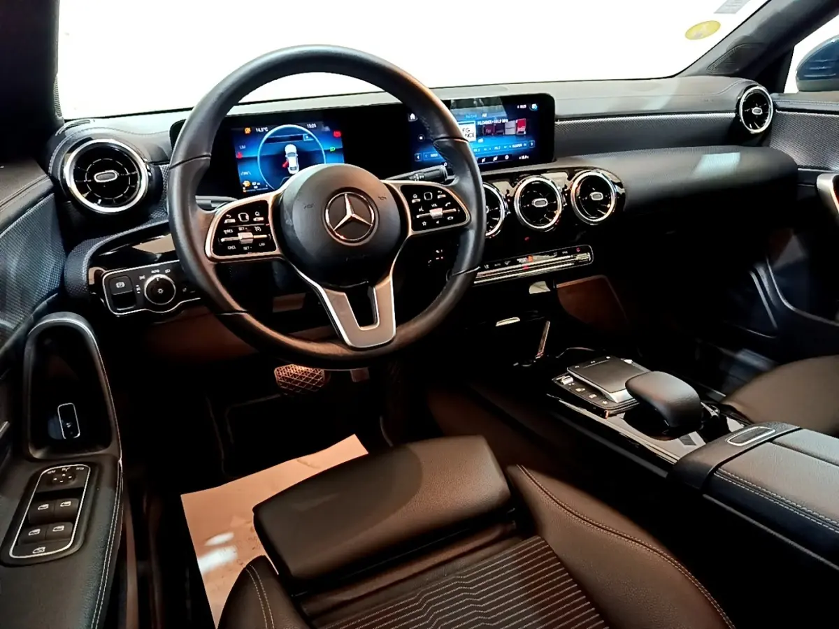 Vue intérieure avant du Mercedes CLA 180 d Business Line 2021, tableau de bord noir avec écran tactile et volant multifonctions cuir alu.
