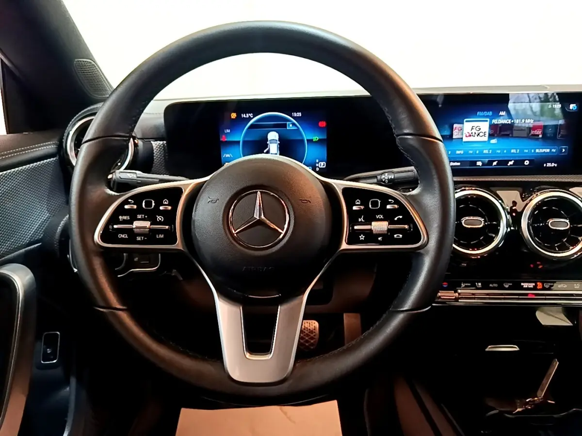 Vue intérieure centrée sur le volant cuir et alu d'une Mercedes CLA 180 d 2021 avec tableau de bord numérique lumineux.