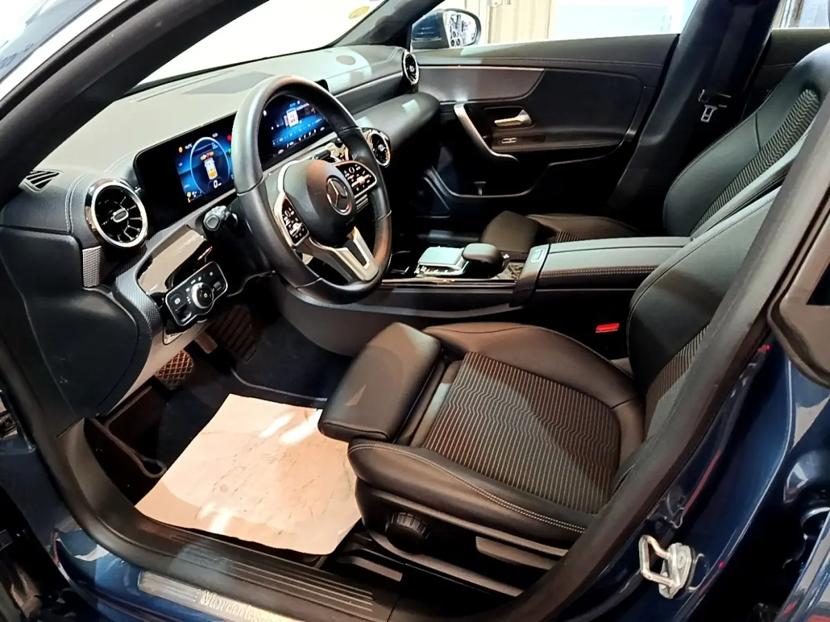 Vue intérieure côté conducteur de la Mercedes CLA 180 d Business Line avec tableau de bord numérique et volant cuir alu multifonctions.