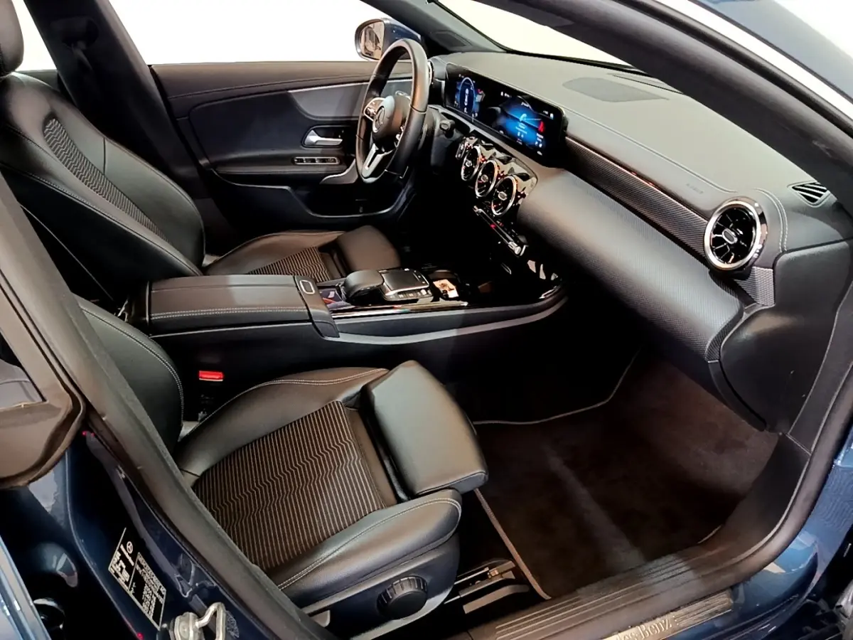 Vue intérieure côté conducteur de la Mercedes CLA 180 d Business Line 2021 avec sièges noirs et tableau de bord numérique.