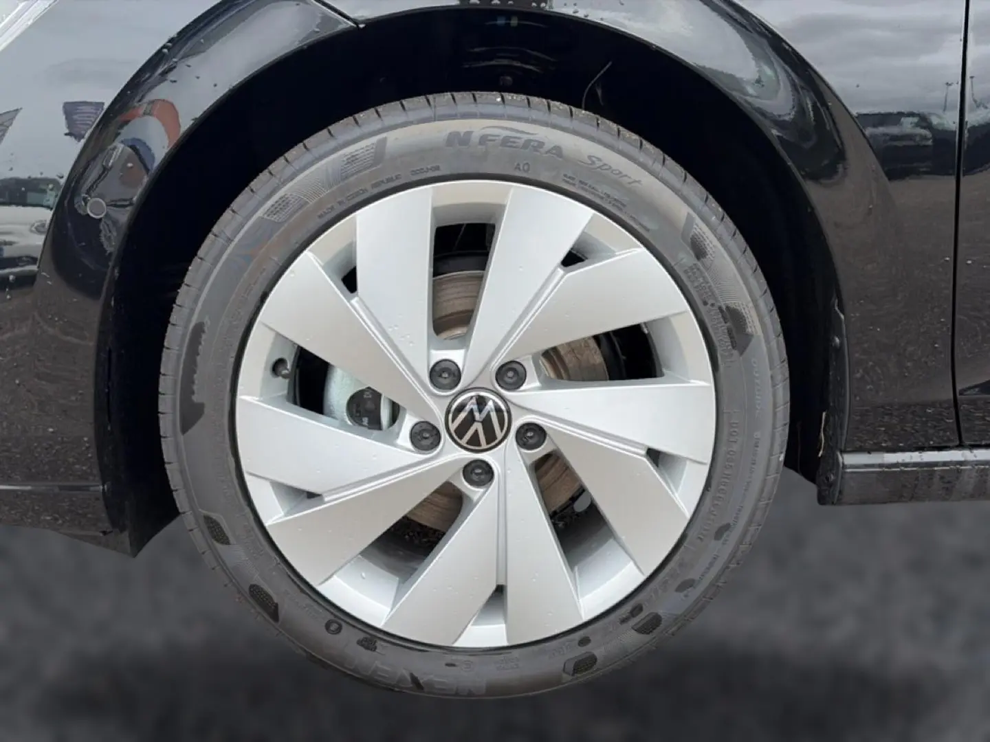 Gros plan sur la roue avant droite noire d'une Volkswagen Golf 1.5 etsi evo2 116 life dsg7 avec jante alu argentée.