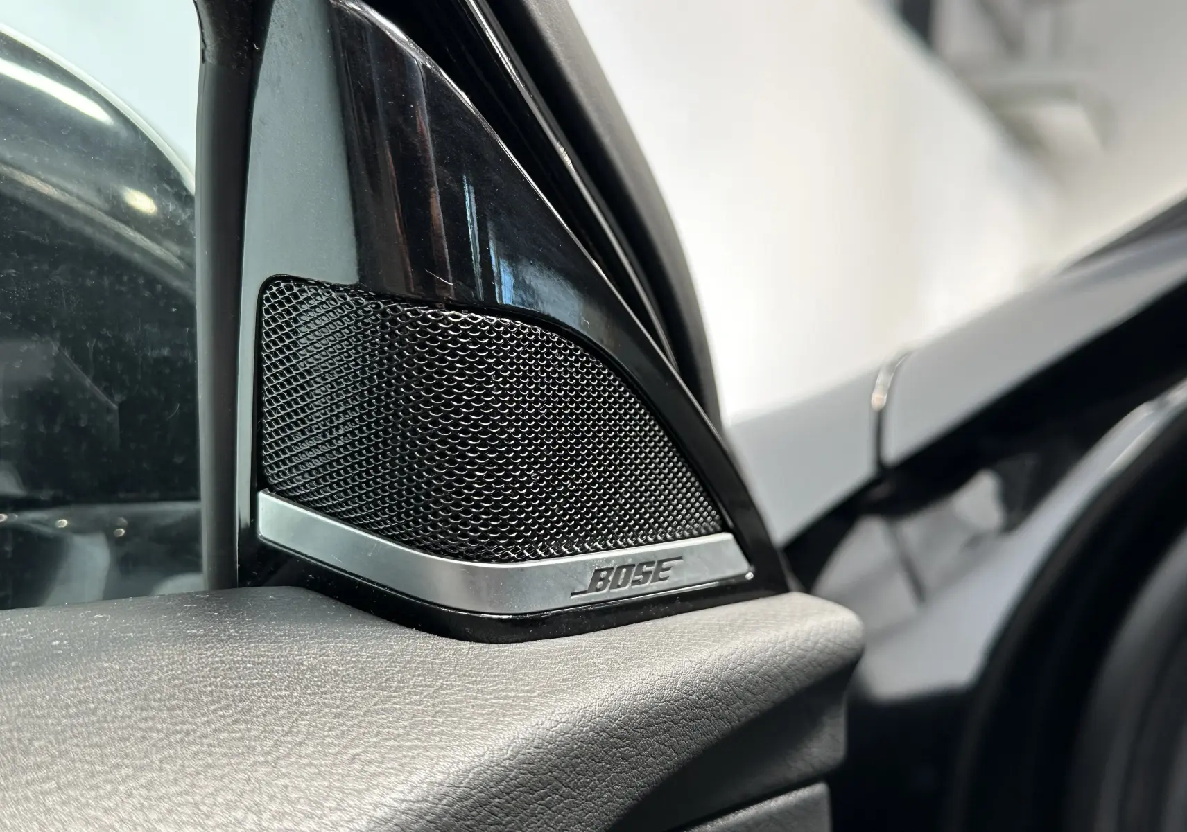 Gros plan sur l'enceinte Bose intégrée à la portière côté gauche d'une INFINITI Q30 noire 2016.
