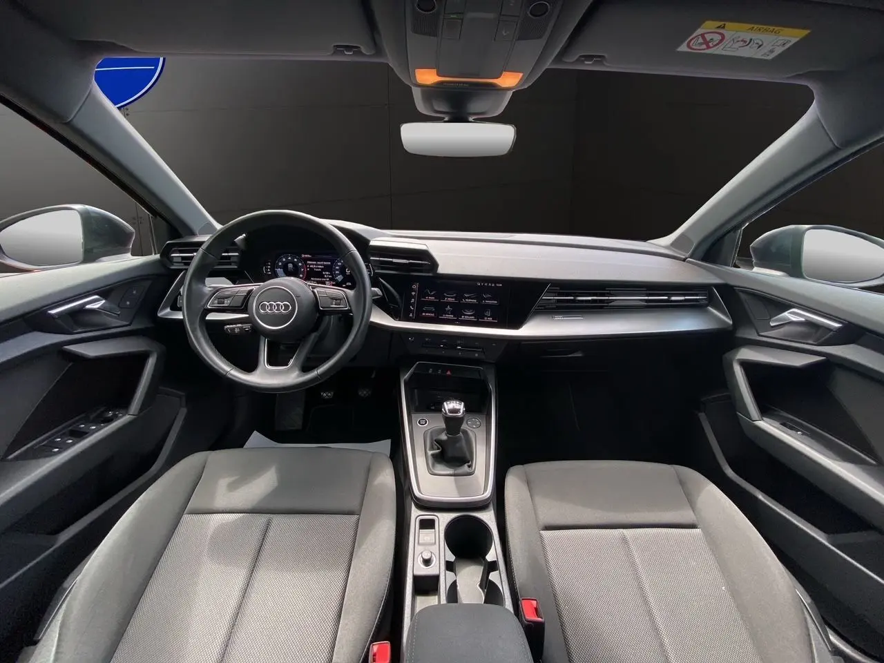 Intérieur noir de l'Audi A3 Sportback 30 TFSI 2021, vue frontale du poste de conduite avec volant et boîte manuelle.