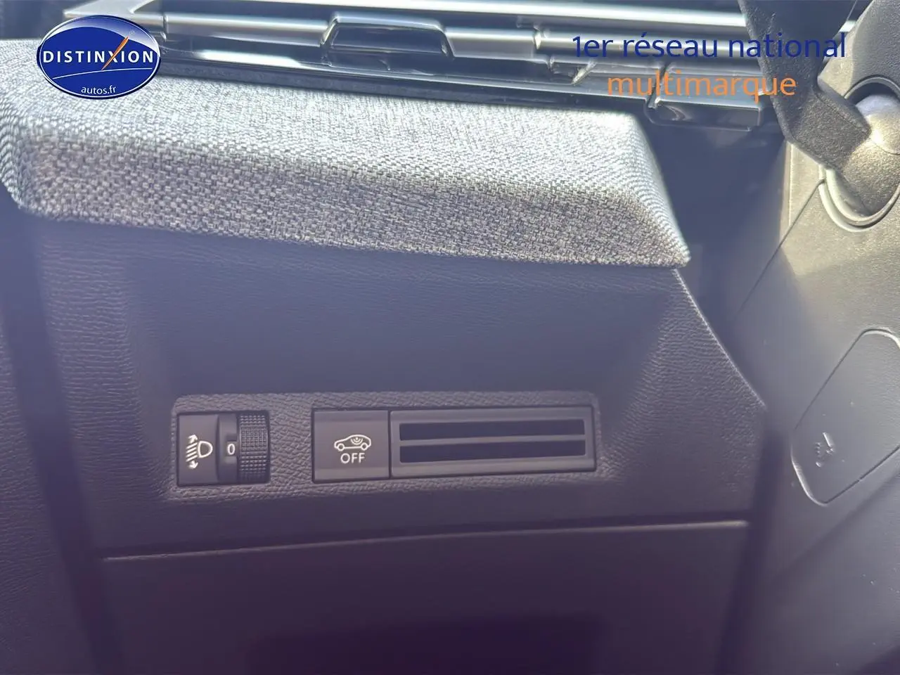 Détail du tableau de bord noir avec commandes d'éclairage et assistance au freinage du Peugeot 3008 gris titane 2025.