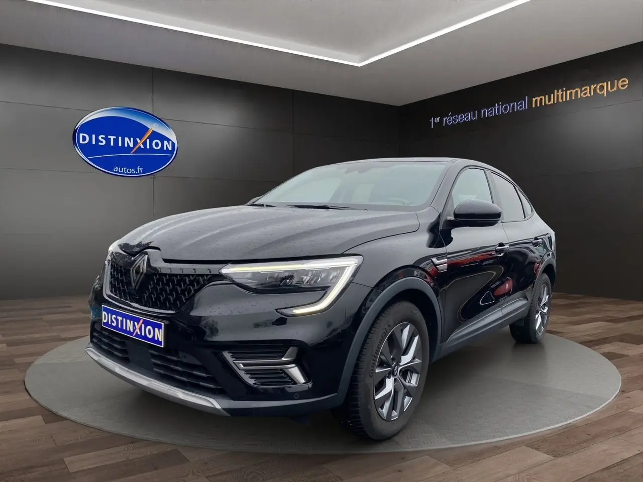Silhouette stylisée d'une Renault Arkana noire vue de profil avec texte "DISTINXION EN ARRIVAGE" en bleu et orange.