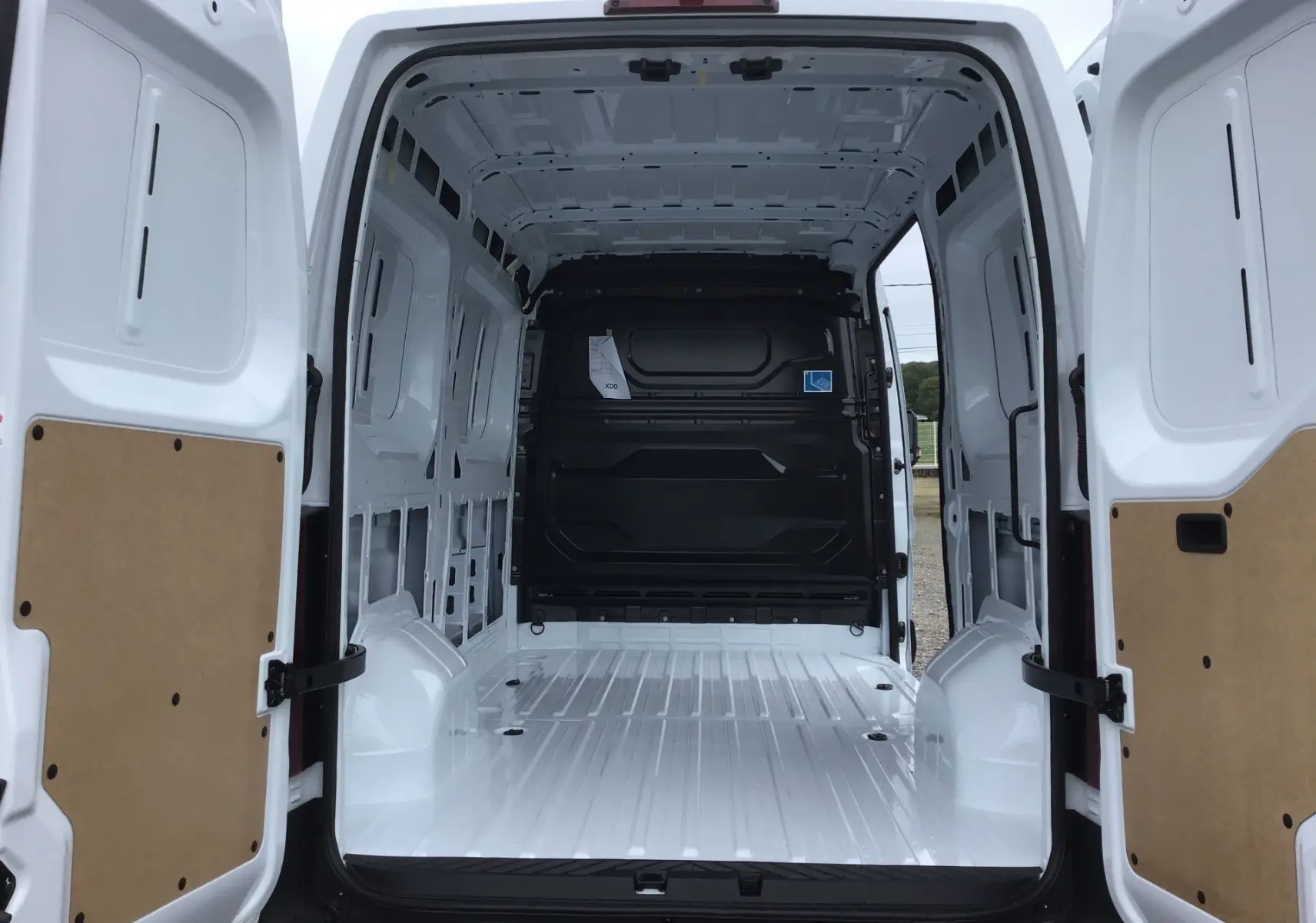 Vue arrière intérieure du Renault Master blanc L2H2 2025, montrant l'espace de chargement vide et les portes ouvertes.