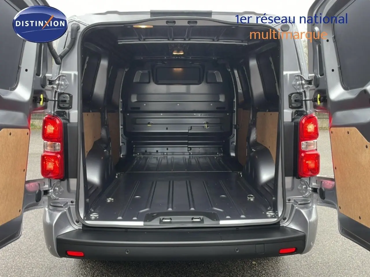 Vue arrière du Citroën Jumpy gris Artense avec portes ouvertes dévoilant un grand espace de chargement vide et protégé.