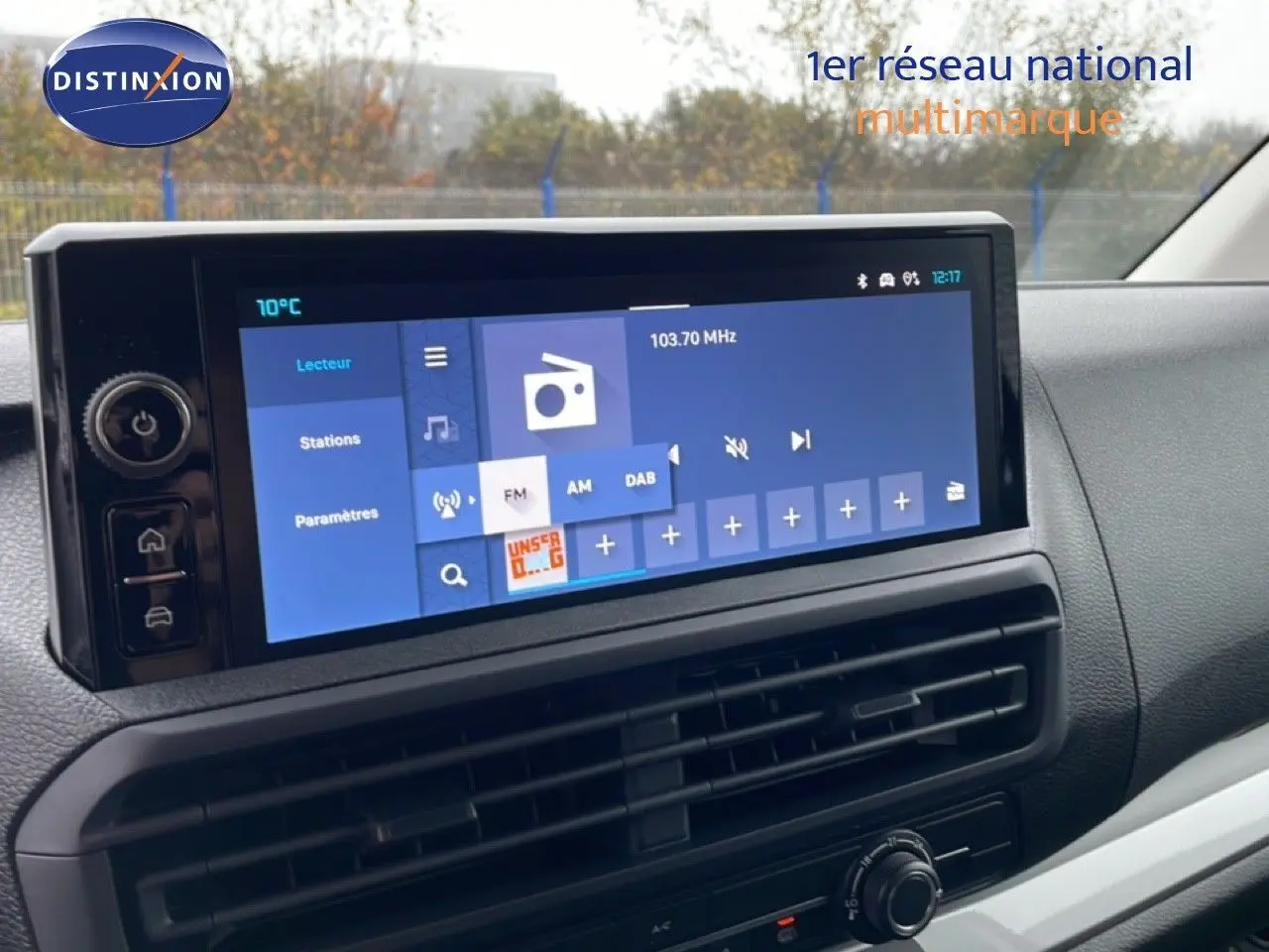 Écran tactile central du tableau de bord du Citroën Jumpy gris, affichant la radio FM à 103,70 MHz.