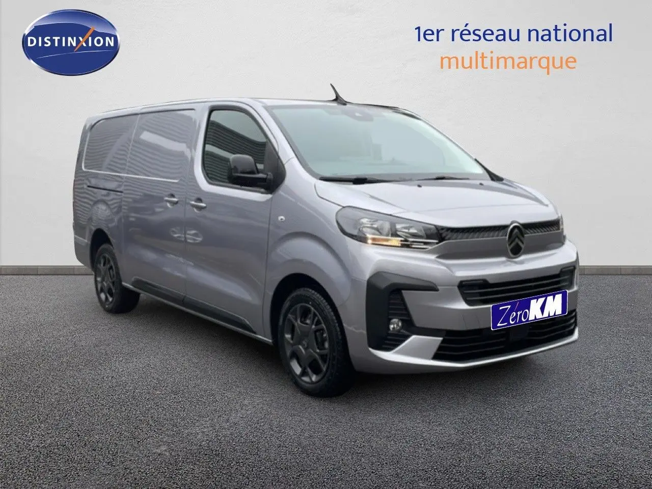 Vue 3/4 avant d'un Citroën Jumpy gris Artense métallisé avec calandre noire et jantes foncées sur sol gris.