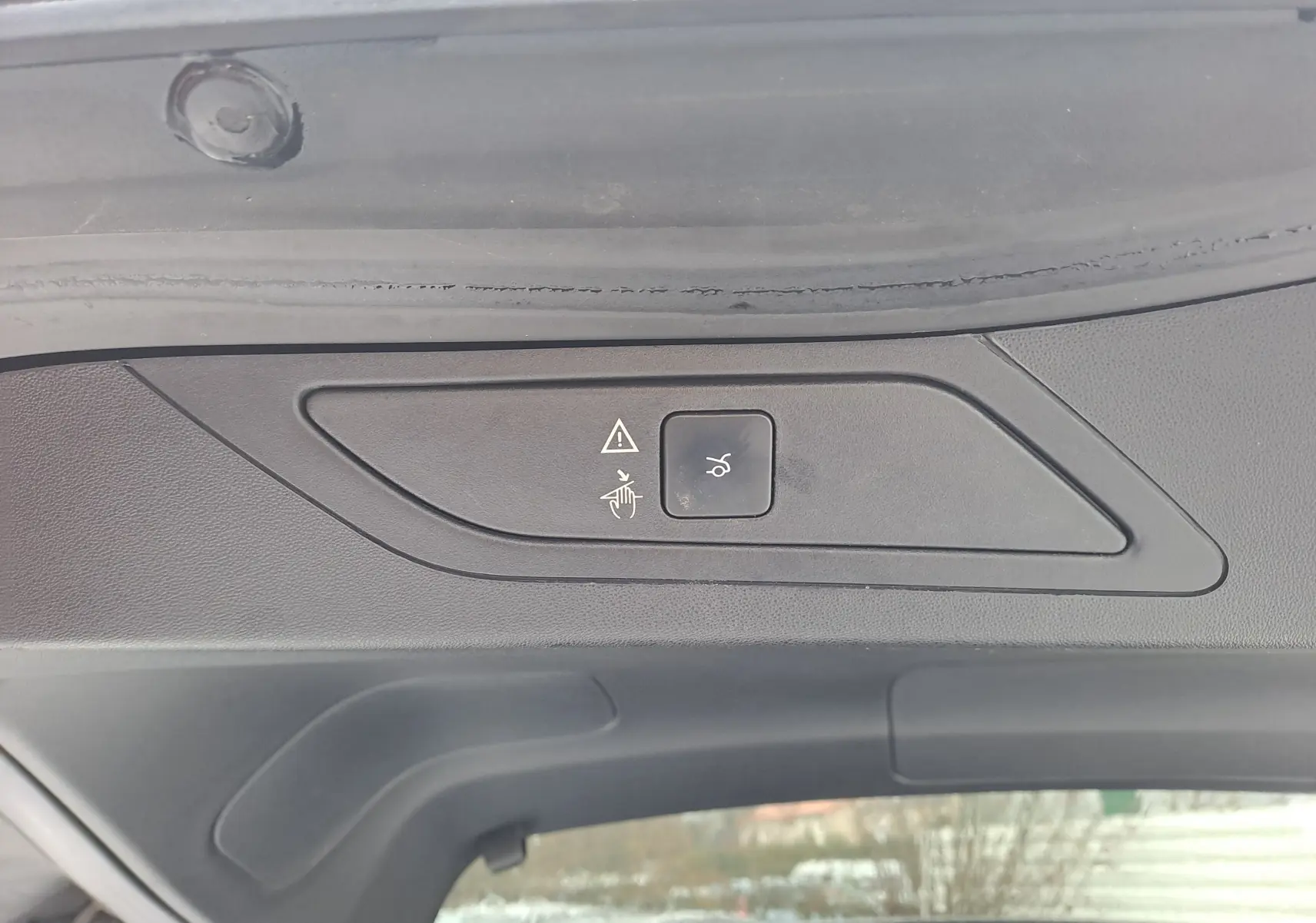 Détail du panneau de commande noir sur le hayon intérieur du Citroën C4 Spacetourer blanc, bouton d'ouverture électrique.