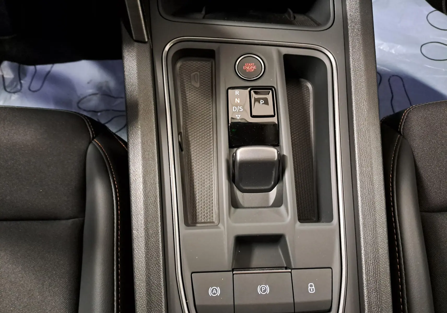 Vue plongeante sur la console centrale de la CUPRA Leon 1.5 TSI 150 DS7 V 2023, avec boîte auto et bouton start/stop.