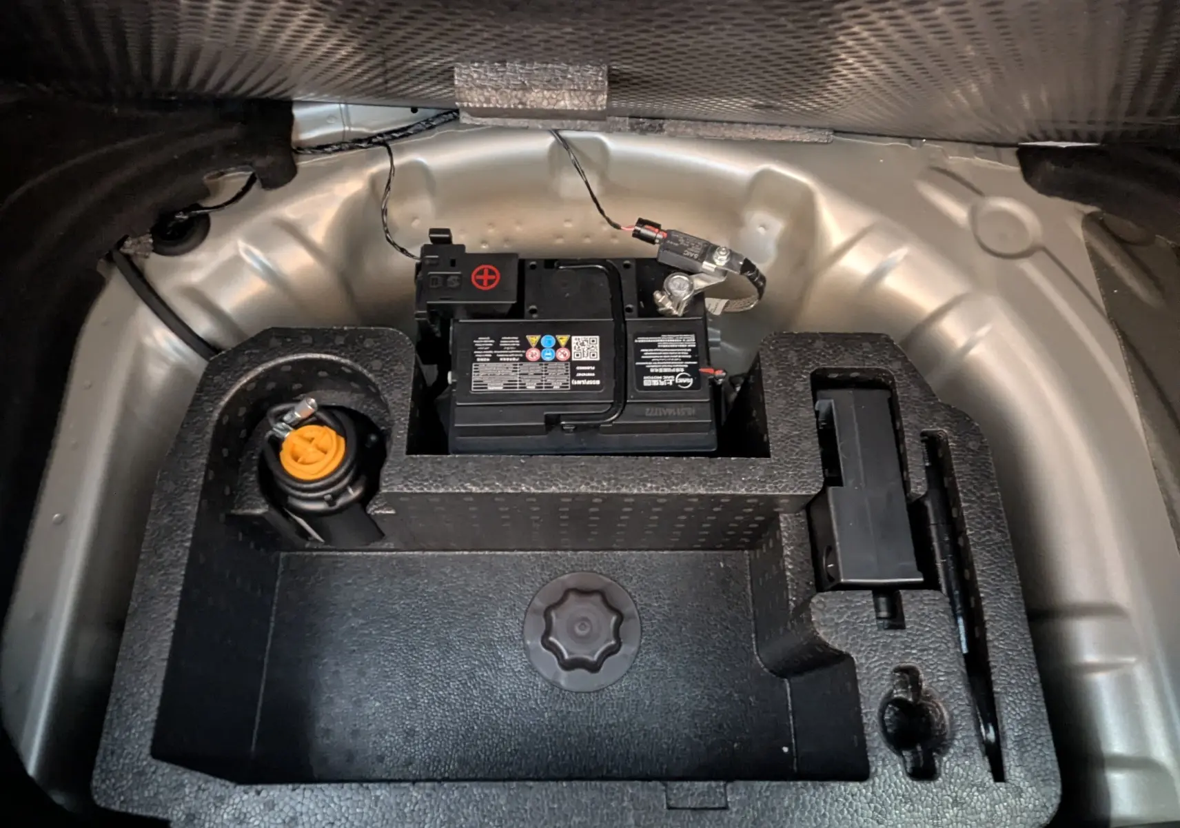 Vue plongeante sur la batterie et le compartiment de rangement dans le coffre du MG3 1.5 L Hybrid+ cosmic silver.