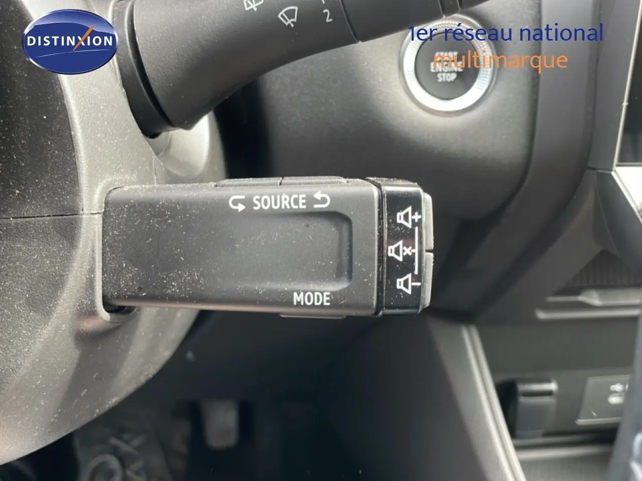 Gros plan sur la commande multimédia au volant du Renault Captur 2025, intérieur noir avec bouton start/stop visible.