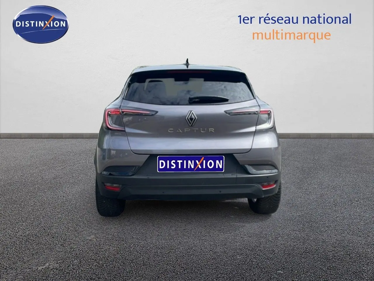 Vue arrière d'un Renault Captur gris Cassiopée métal avec toit noir, montrant ses feux LED et son logo central.
