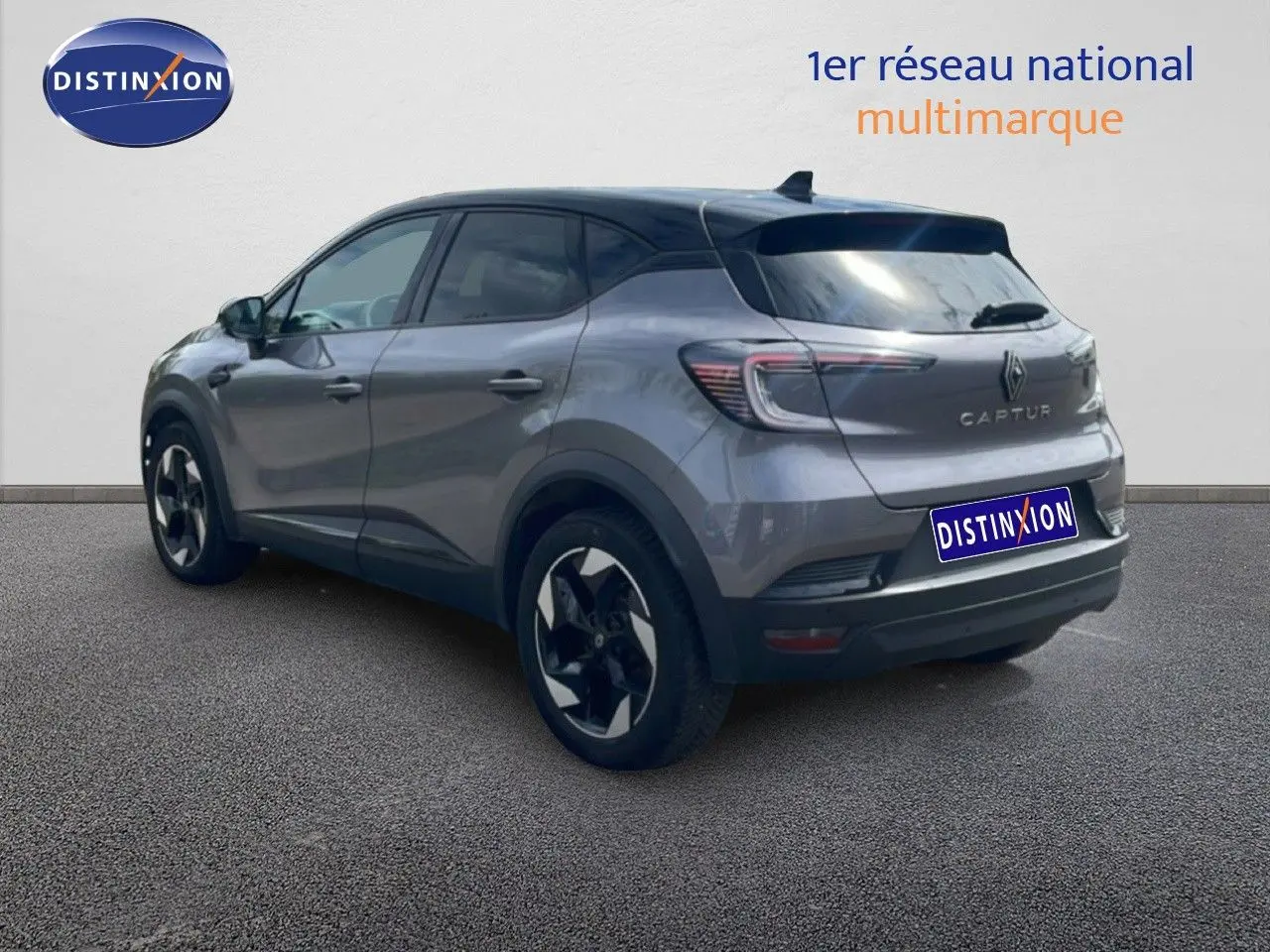 Vue 3/4 arrière droite d’un Renault Captur gris cassiopée métal avec toit noir et jantes bi-ton.