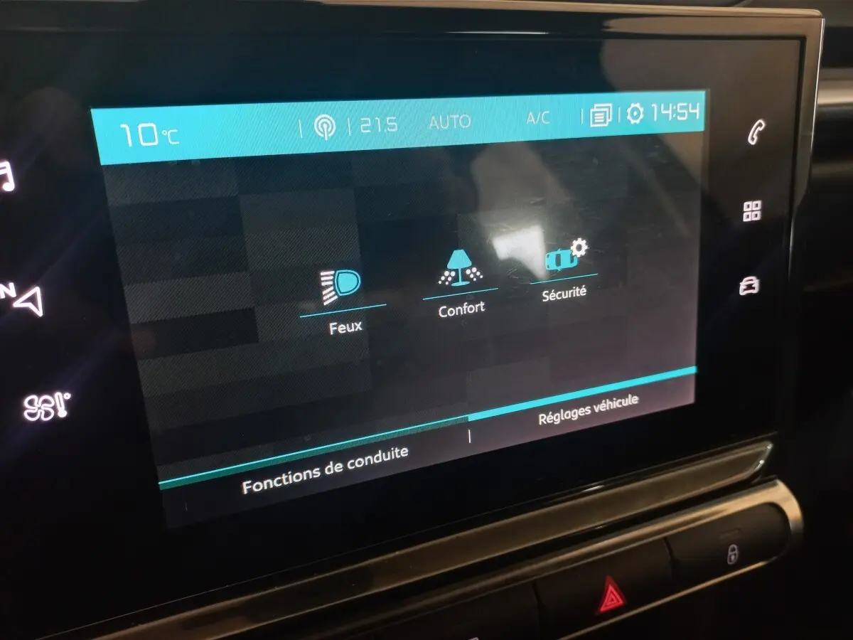 Écran tactile central de la Citroën C3 2024 affichant les réglages Feux, Confort et Sécurité en intérieur noir.