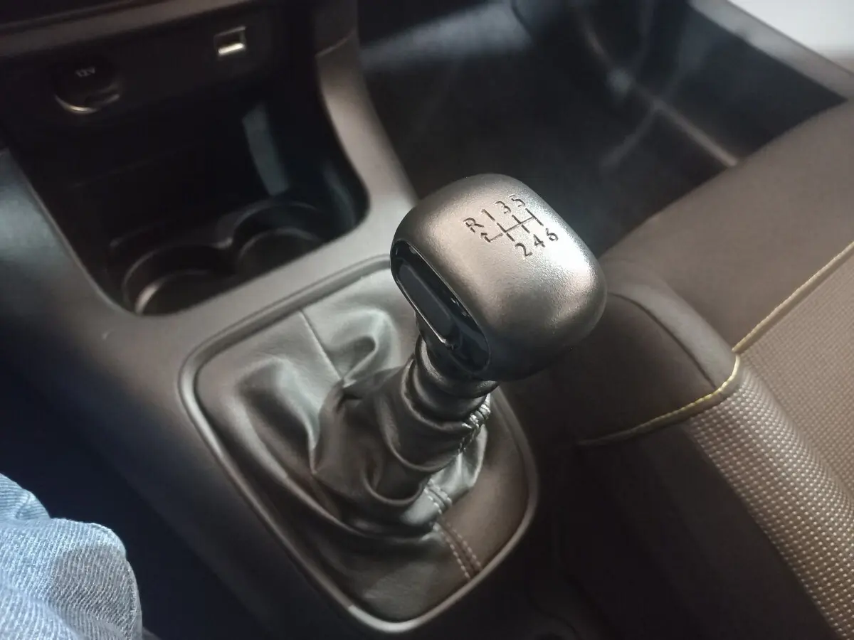 Gros plan sur le levier de vitesses manuel noir de la Citroën C3 2024, avec siège tissu marron à côté.