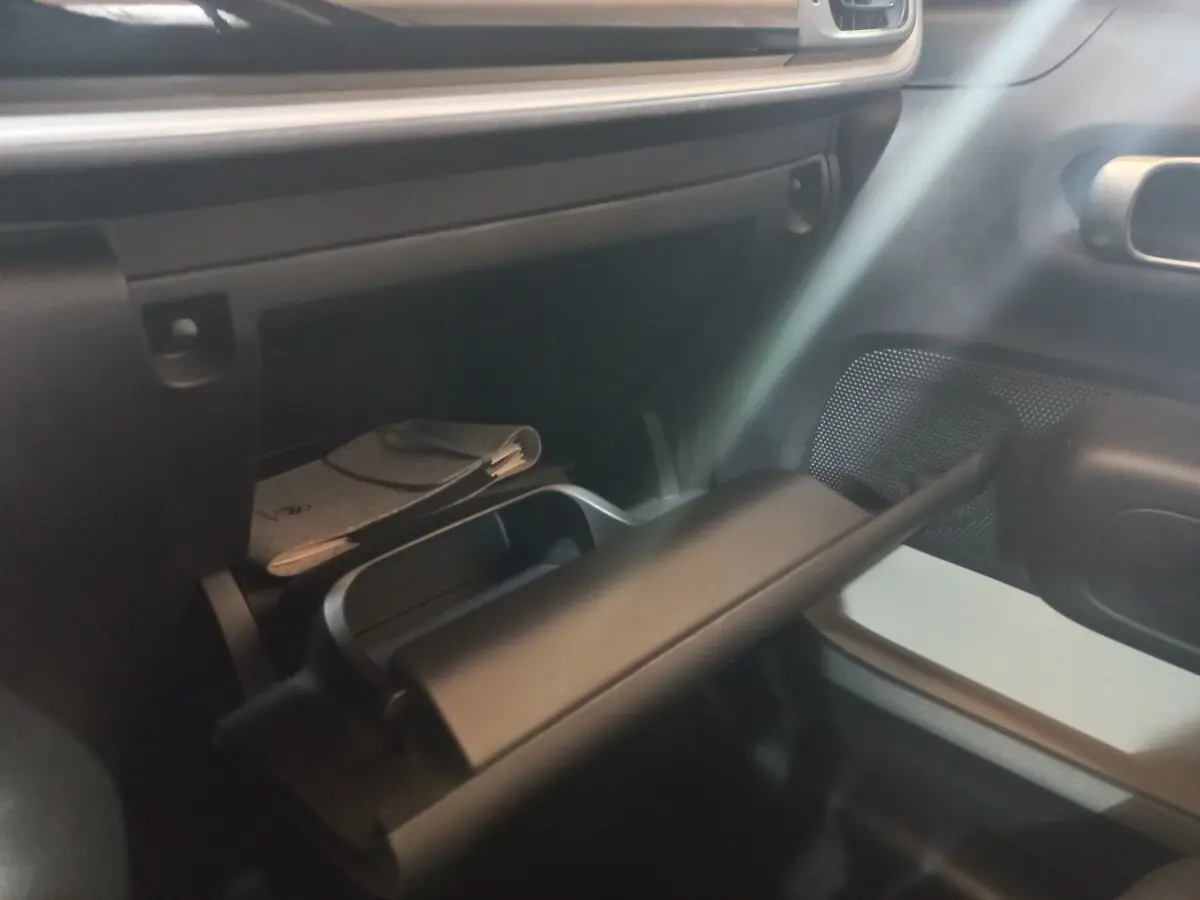 Intérieur de la Citroën C3 2024, vue sur la boîte à gants ouverte côté passager avec rangement et documentation.