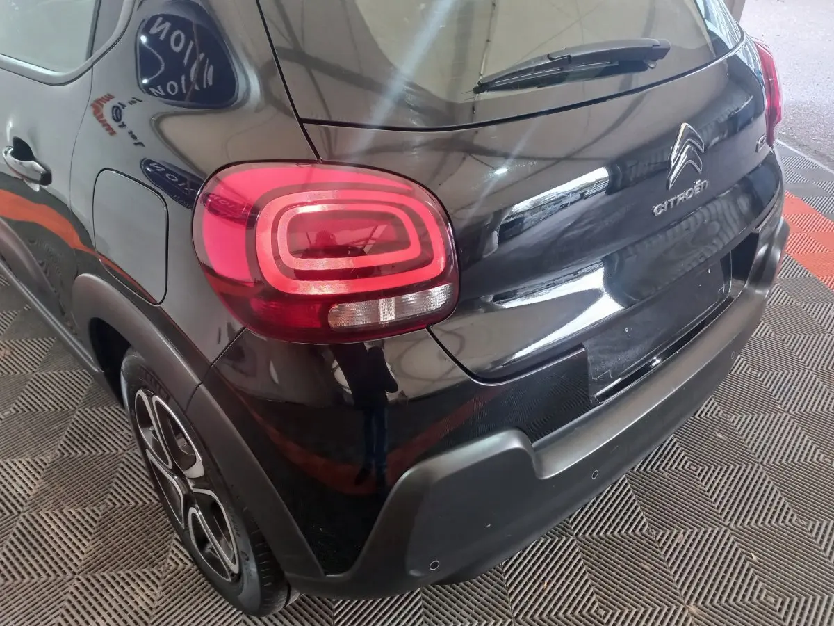 Vue 3/4 arrière droite d'une Citroën C3 noire 2024 avec feux arrière LED distinctifs et jantes stylisées.