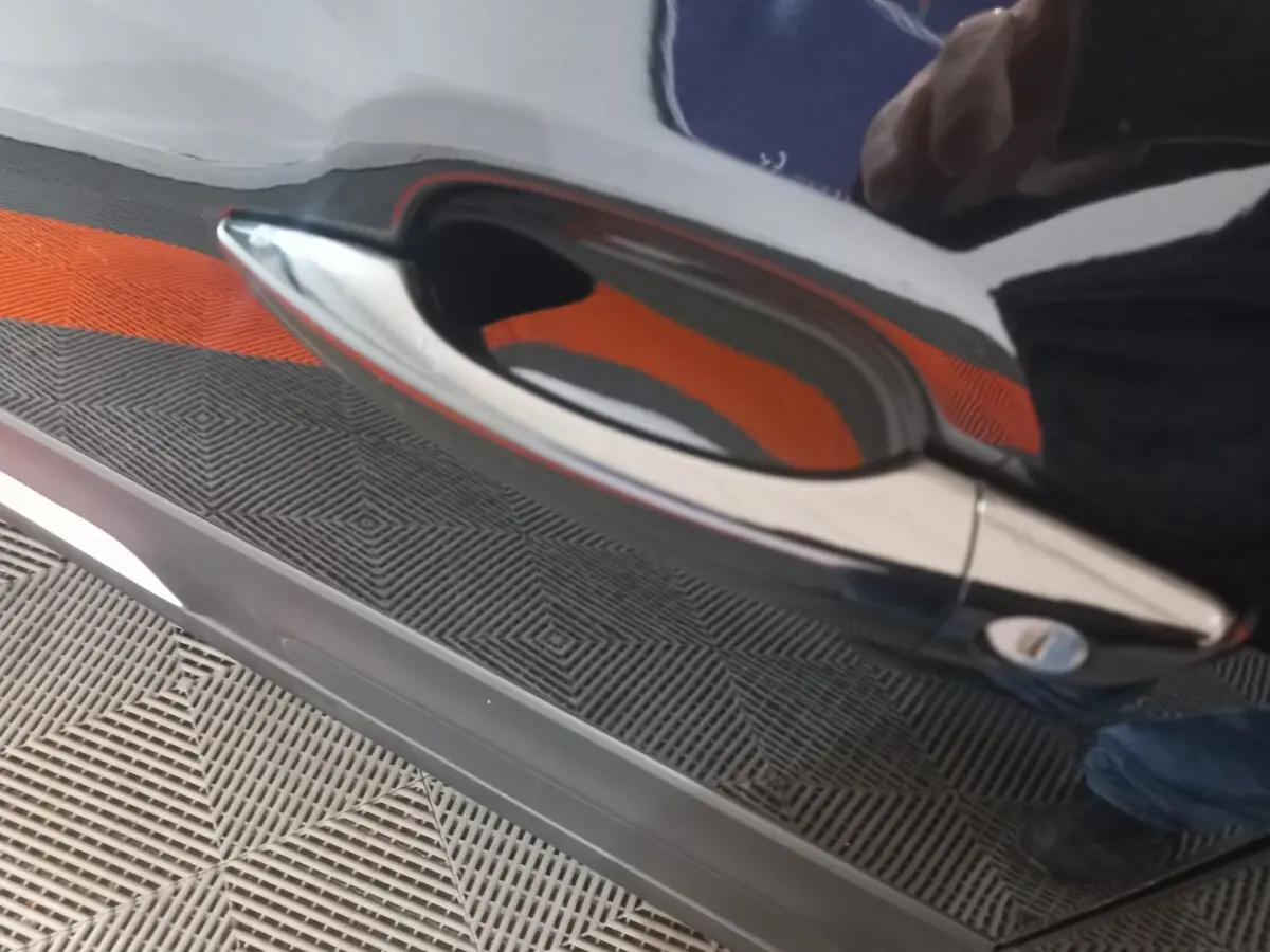 Poignée de porte chromée sur la portière noire côté droit d'une Citroën C3 BlueHDi 100 BVM PLUS 2024.