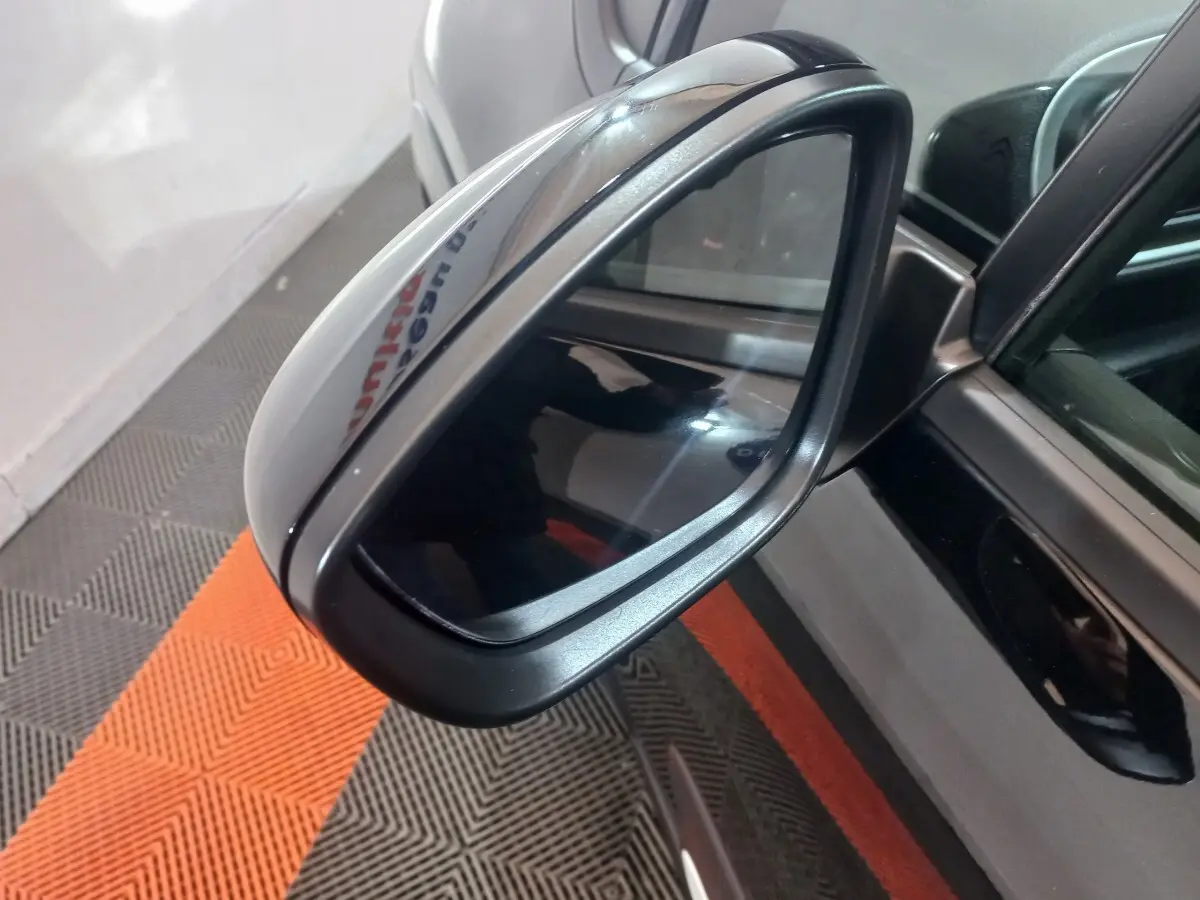 Rétroviseur extérieur côté conducteur noir de Citroën C3 2024, vue rapprochée sur la surface miroir et la carrosserie.
