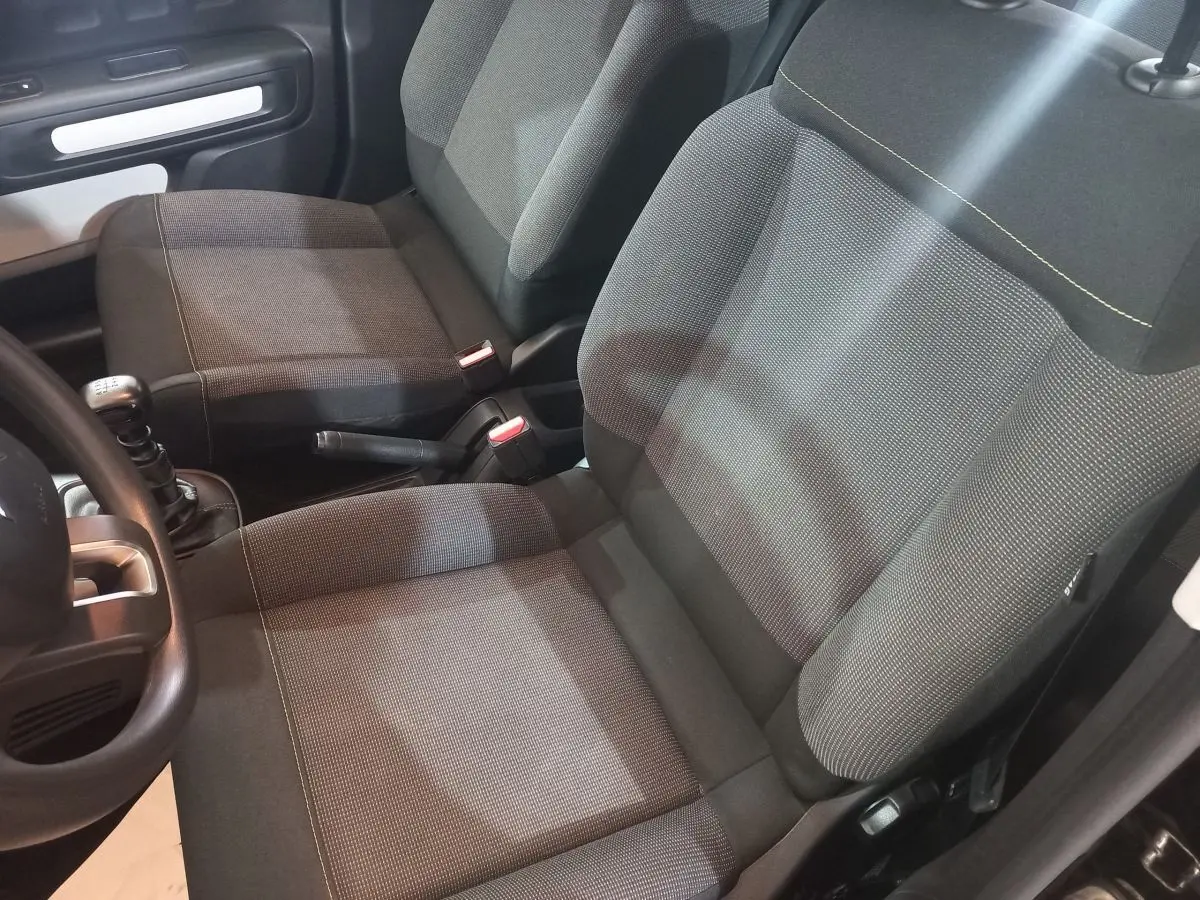 Vue intérieure rapprochée des sièges avant gris foncé de la Citroën C3 2024 avec levier de vitesse manuel visible.