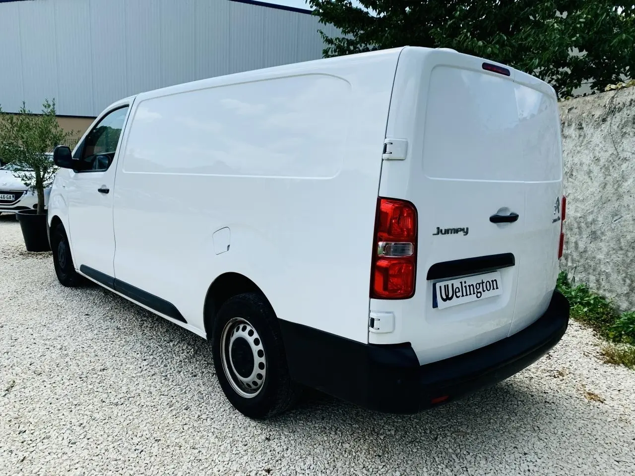 Vue 3/4 arrière droite du Citroën Jumpy XL blanc, fourgon utilitaire avec portes battantes arrière et jantes acier.