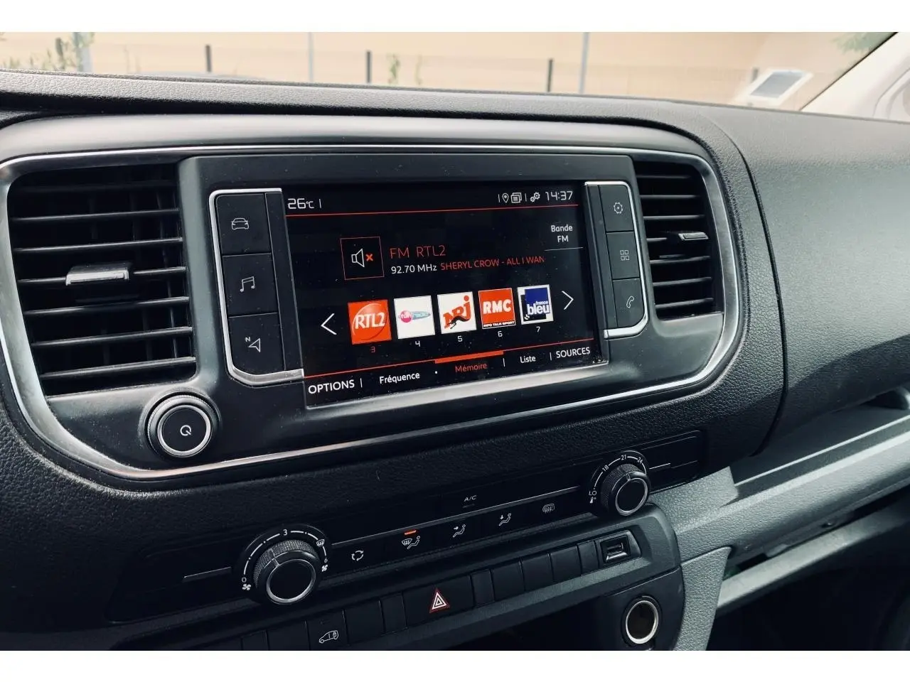 Tableau de bord noir du Citroën Jumpy XL 2020 avec écran tactile affichant les radios FM et commandes de climatisation.