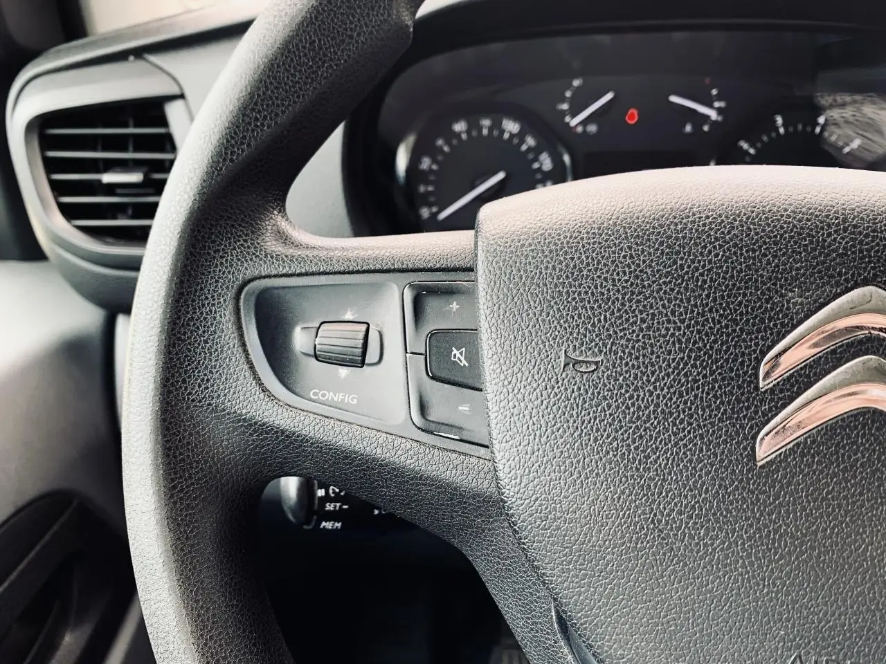 Gros plan sur le volant noir de la Citroën Jumpy XL 2020 avec commandes intégrées et logo chromé visible.