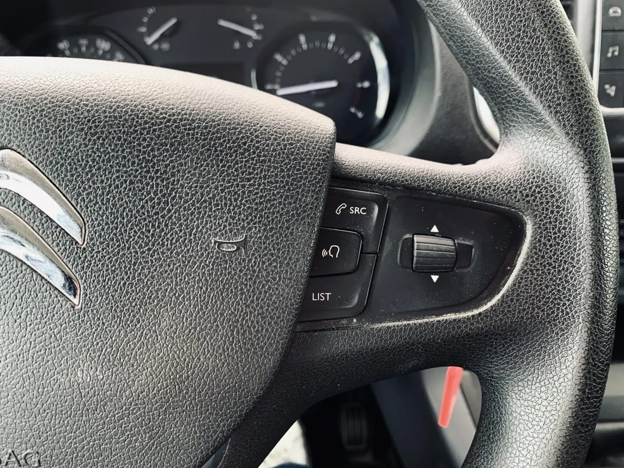 Gros plan sur le volant noir du Citroën Jumpy XL 2020 avec commandes audio intégrées et tableau de bord en arrière-plan.