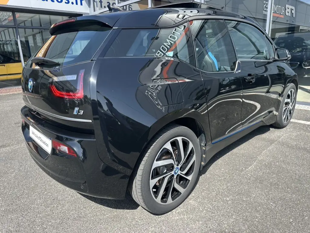 Vue 3/4 arrière côté gauche d'une BMW I3 noire électrique 2022 avec jantes distinctives et vitres teintées.