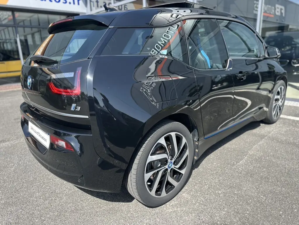 Vue 3/4 arrière droite d'une BMW i3 noire électrique 2022 avec jantes distinctives et vitres teintées.