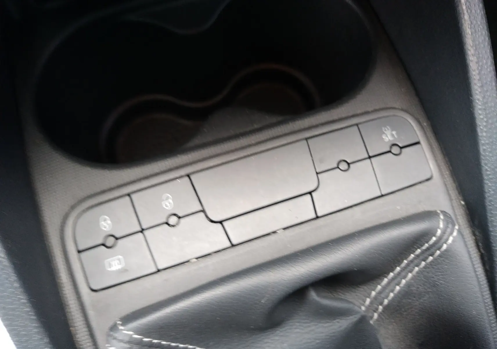 Gros plan sur la console centrale d'une SEAT Ibiza ST rouge, mettant en valeur le levier de vitesse manuel et les boutons de commande.