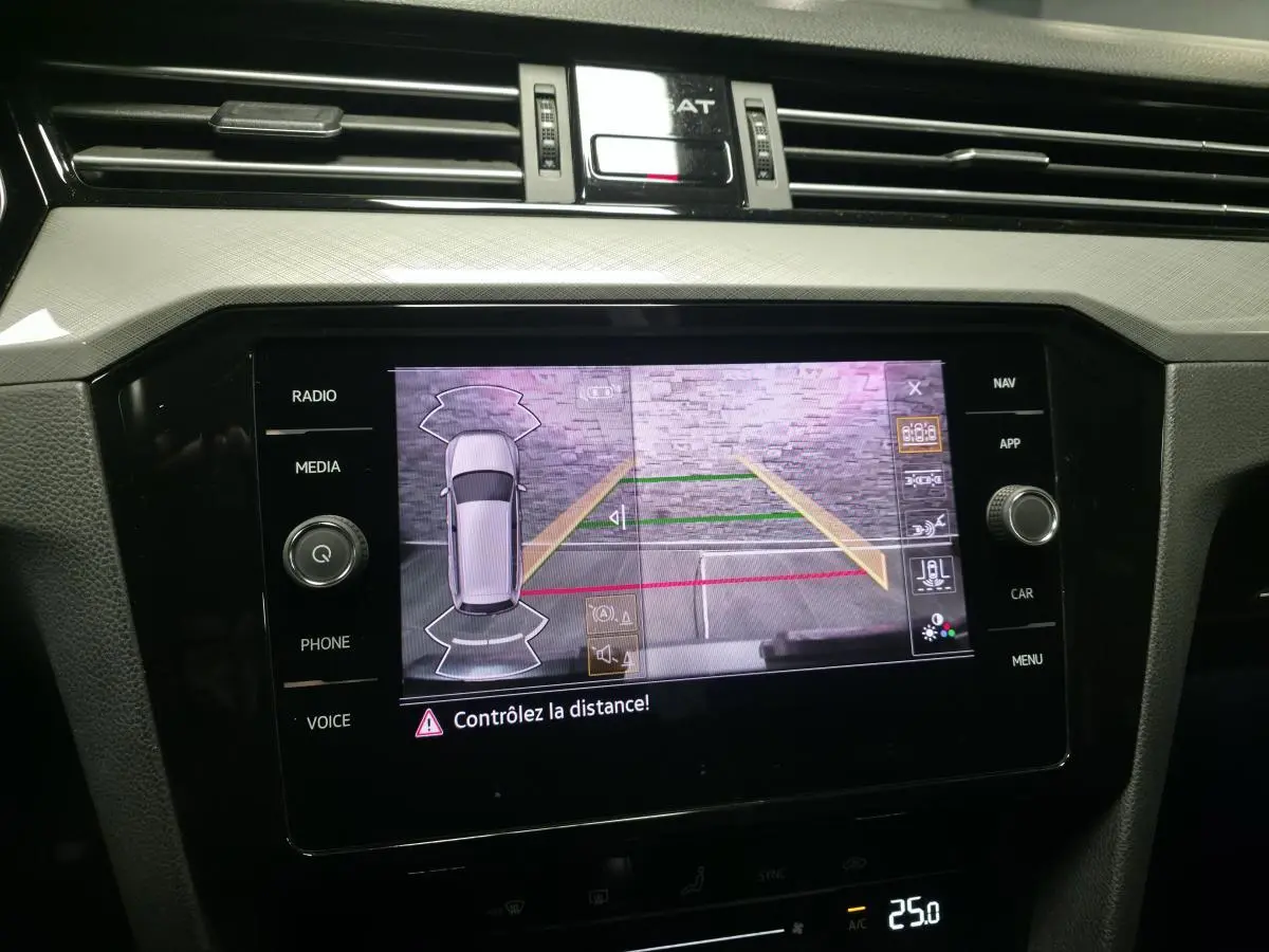 Écran tactile central de la Volkswagen Passat SW gris montrant la caméra de recul avec guidage de stationnement.