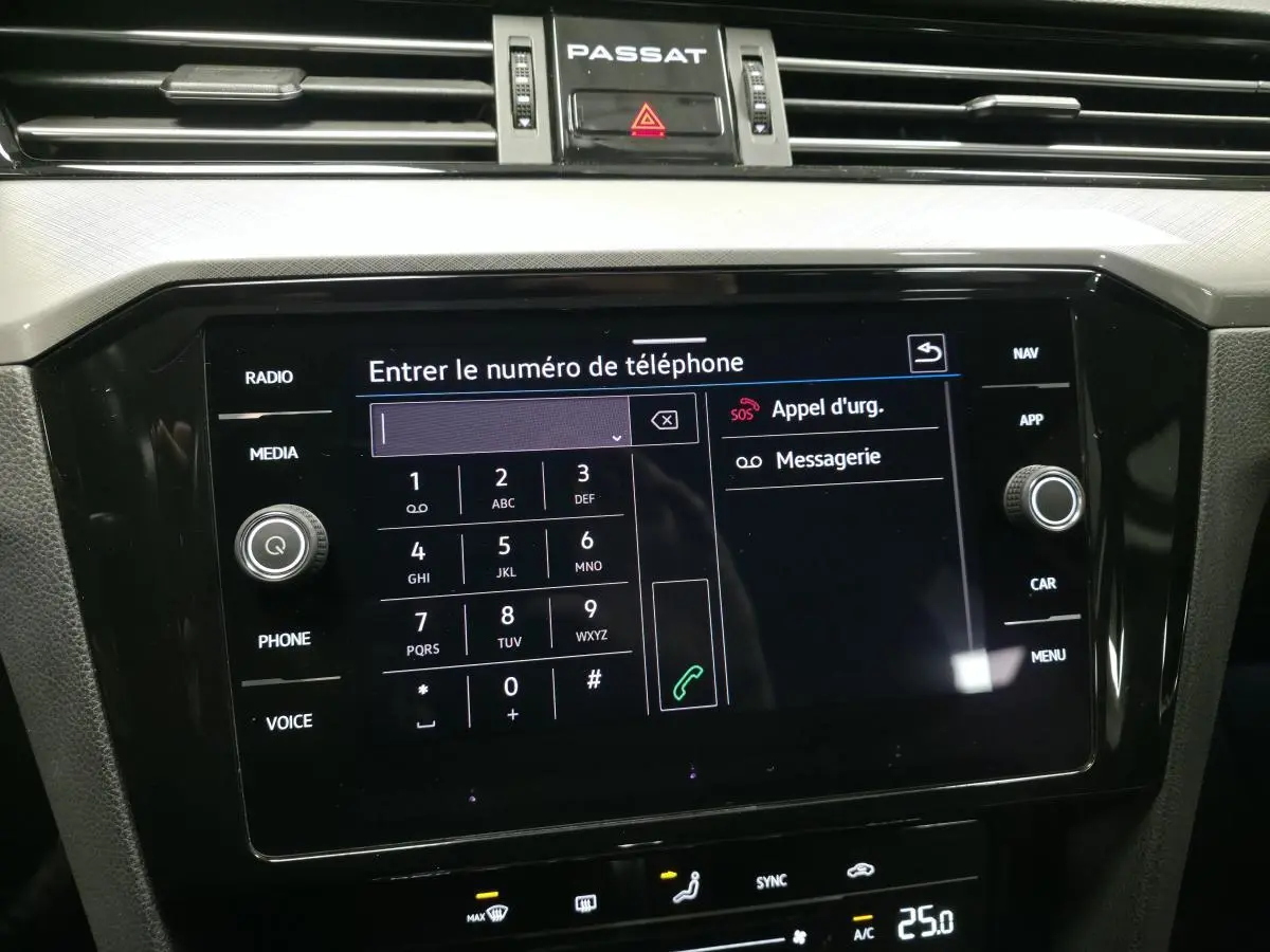 Écran tactile central noir du tableau de bord de la Volkswagen Passat SW gris, affichant le clavier pour entrer un numéro.