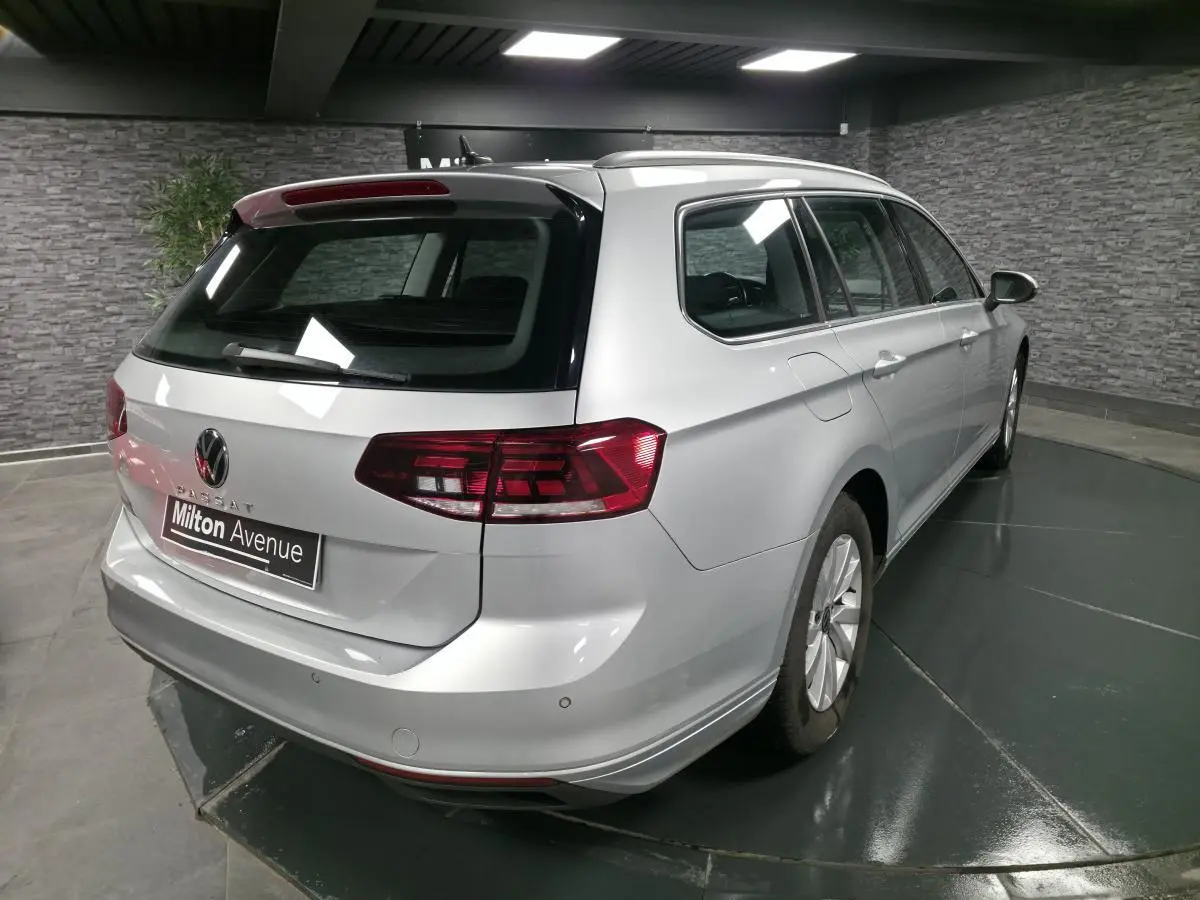 Volkswagen Passat SW gris vue 3/4 arrière droit en intérieur avec feux arrière LED et jantes alliage.