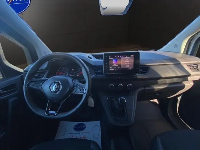 Vue intérieure du tableau de bord du Renault Kangoo Van TCE 100 blanc, avec volant à gauche et écran tactile central.