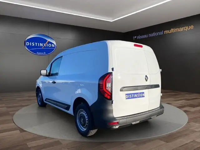 Vue 3/4 arrière droite du Renault Kangoo Van blanc 2023 avec kit bois complet, présenté en showroom intérieur.