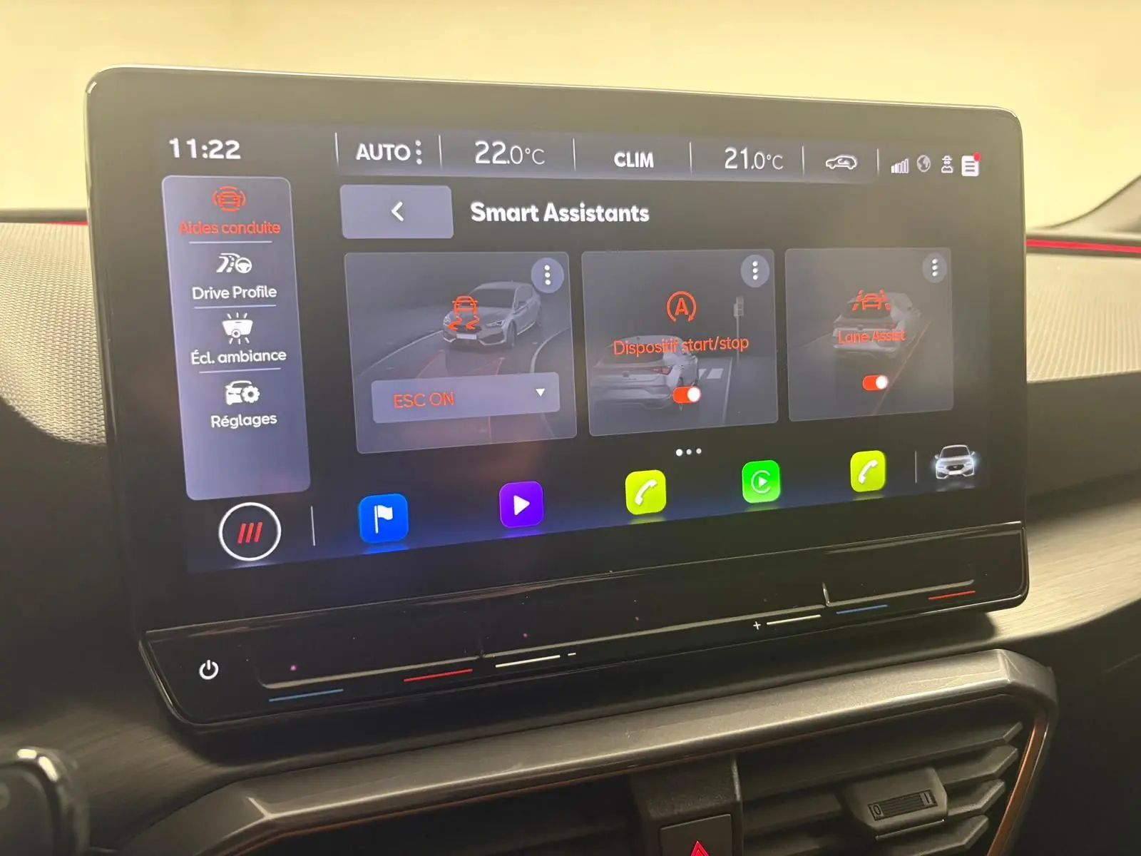Écran tactile intérieur du CUPRA Leon 2024 montrant les assistants de conduite activés dans un habitacle moderne.