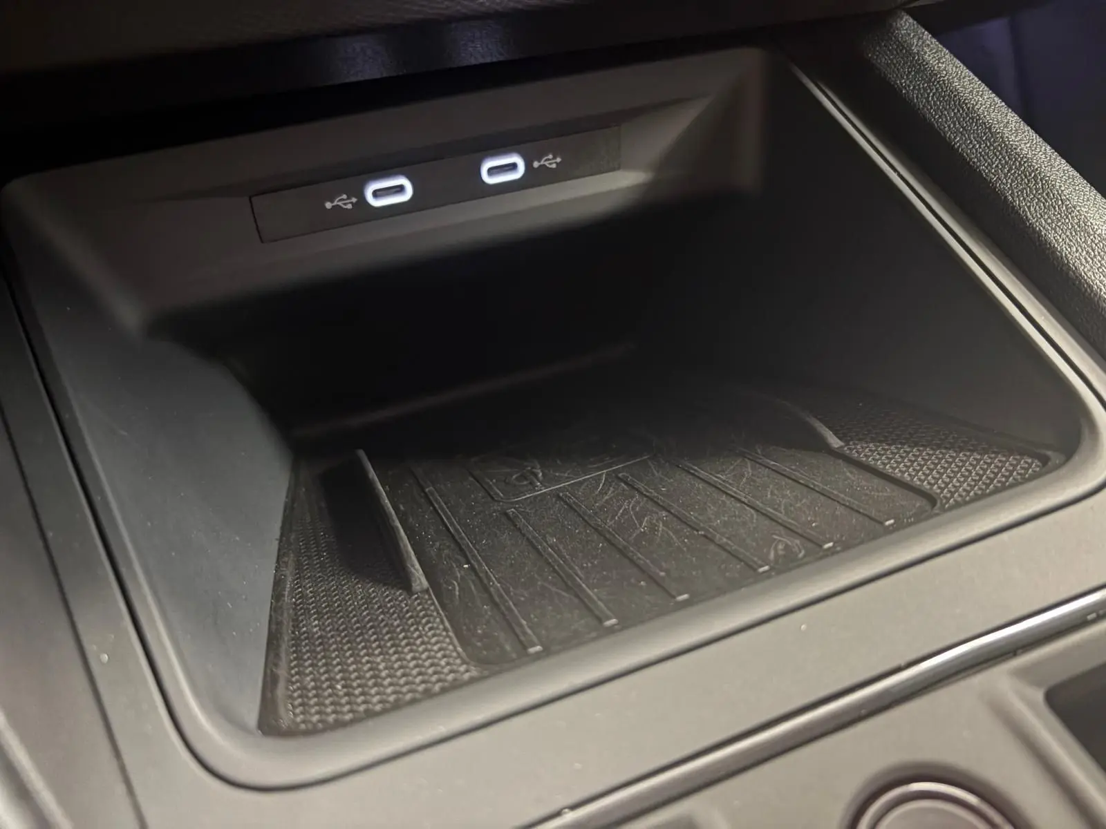 Gros plan sur le compartiment de rangement noir avec deux ports USB-C éclairés dans une CUPRA Leon 2024.