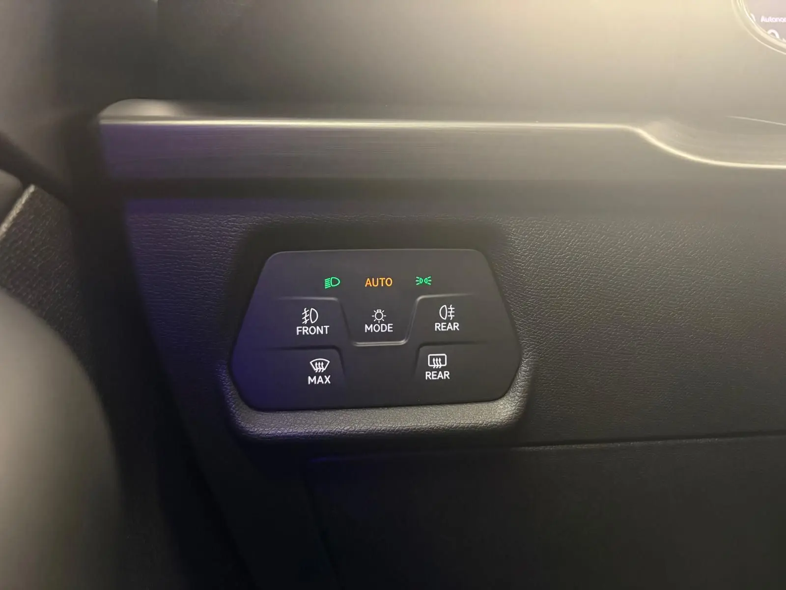 Gros plan sur les commandes d’éclairage automatiques du tableau de bord d’une CUPRA Leon blanche.